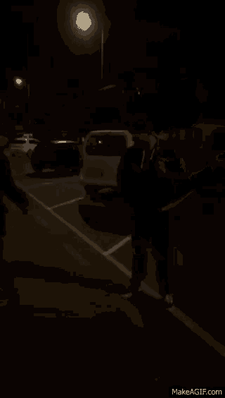 a silhouette of a person riding a skateboard down a street at night .