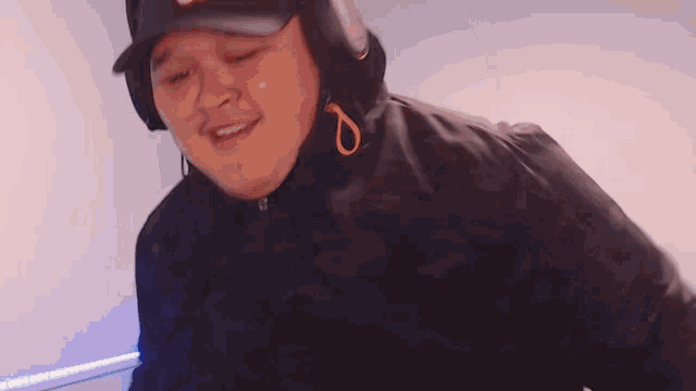 a man wearing headphones and a black jacket with a hood