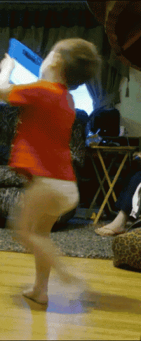 a little boy in a red shirt is jumping in the air