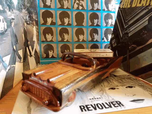 a wooden toy car sits on a revolver record