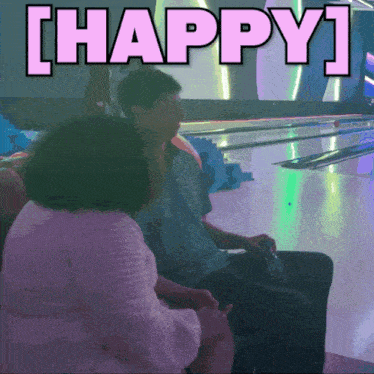 a man and a woman are sitting at a bowling alley with the words happy written above them