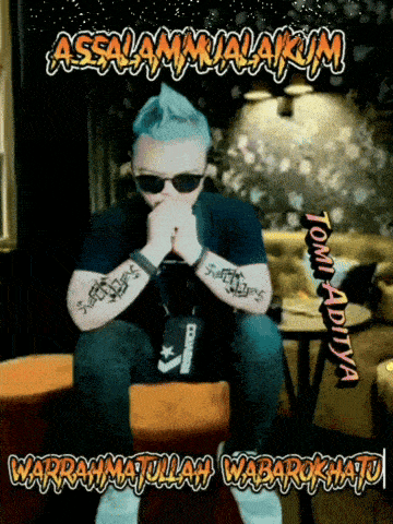 a man wearing sunglasses and a converse bag sits on a couch with his hands folded in front of him