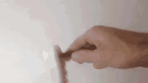 a close up of a person 's hand holding a screwdriver in a light switch .
