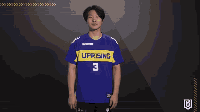 a man wearing a blue and yellow uprising jersey number 3