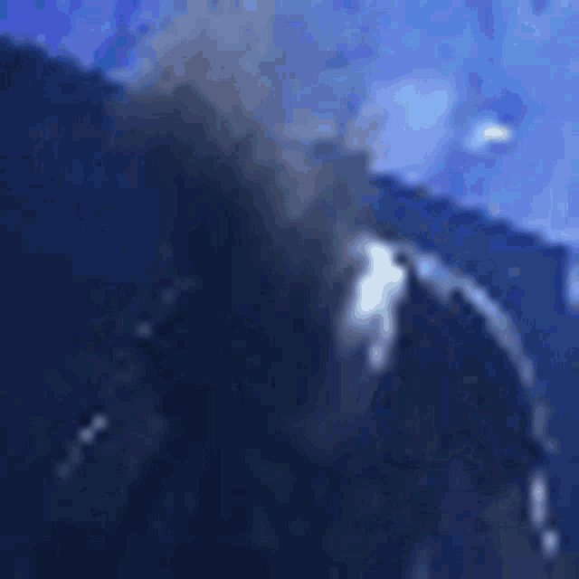 a blurry picture of a person 's face in a dark room with blue lights .