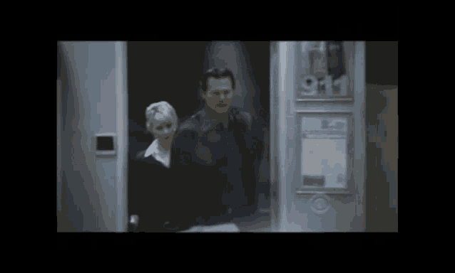 a man and a woman are walking into a building with a sign that says 911
