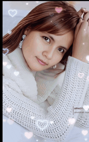 a woman in a white sweater with hearts surrounding her