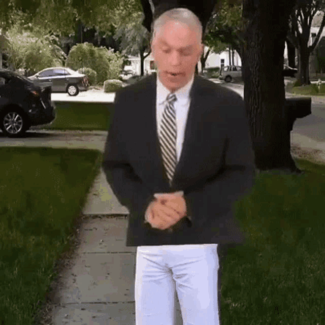 a man in a suit and tie is standing on the sidewalk