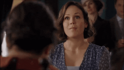 a woman in a blue dress is making a face