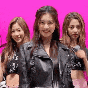 a group of three girls are standing next to each other on a pink background .