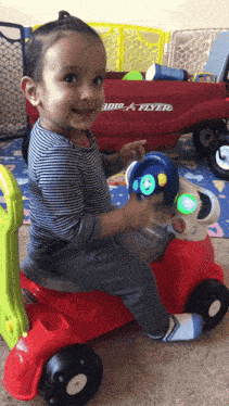 a little boy is playing with a red radio flyer wagon