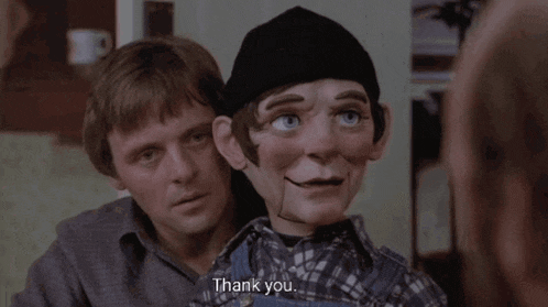 a man holding a puppet with the words thank you on it