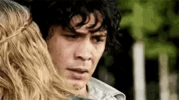 a man and a woman are standing next to each other and hugging .