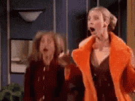 two women are standing next to each other with their mouths open .