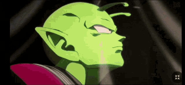 a close up of a green cartoon character with a red collar and a black background