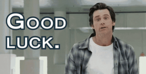 a man in a plaid shirt stands in front of a sign that says good luck