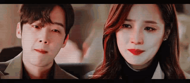a man and a woman are looking at each other . the woman is crying and the man is smiling .