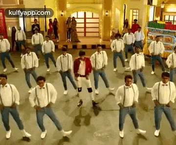 a group of men are dancing together on a stage in a room .