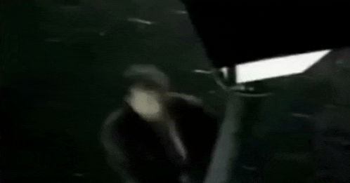 a blurry picture of a person standing in a dark room .