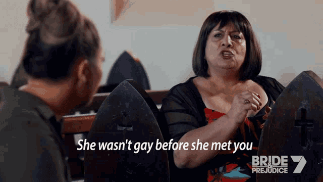 two women sitting in a church with the words she wasn 't gay before she met you on the bottom