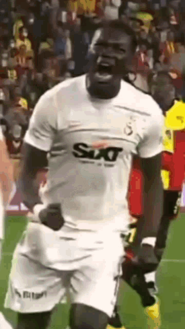 a soccer player wearing a sixt shirt is celebrating on the field .