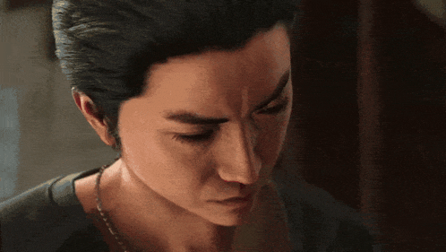 a man with a necklace around his neck looks down at something
