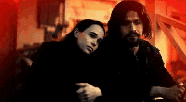a man and a woman are sitting next to each other .