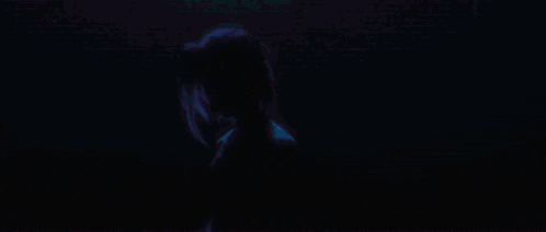 a man and a woman with blue hair are standing next to each other in a room .