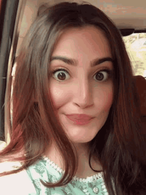 a close up of a woman making a funny face in a car
