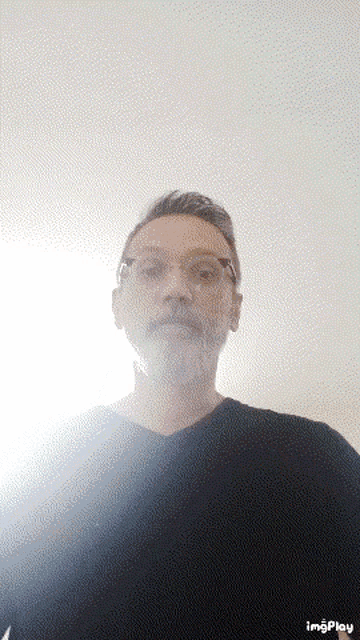 a man with a beard wearing glasses and a black shirt