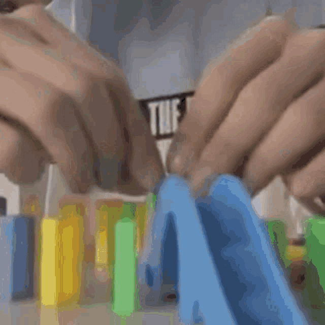 a man in a shirt that says " the out " is playing with dominoes