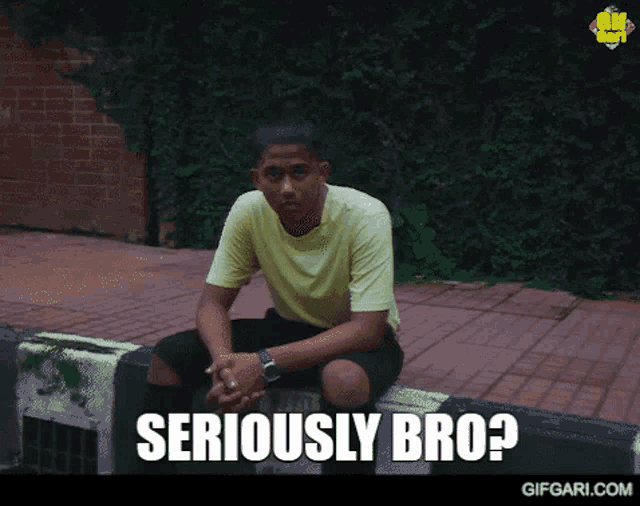 a man in a yellow shirt is sitting on a curb with the words seriously bro written below him