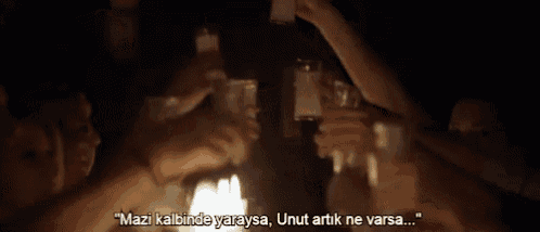 a group of people are sitting around a table holding glasses of alcohol .