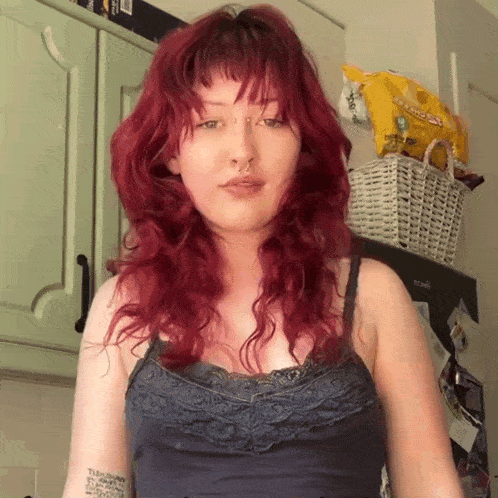 a woman with red hair has a tattoo on her arm that says ' i am a woman '