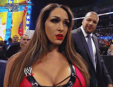 a woman in a red top with a w logo on it stands next to a man in a suit and tie