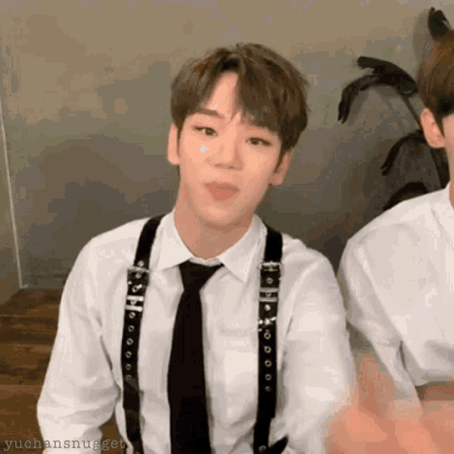 a young man wearing suspenders and a white shirt with the name yuchansnugget on the bottom right