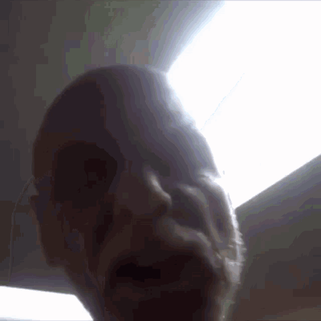 a close up of a man 's face with the sun shining through the window