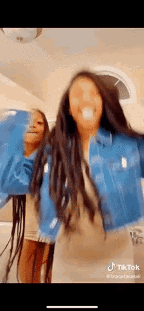 a couple of women are dancing together on a tik tok video .