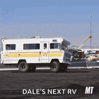 a white and yellow rv is parked on the side of the road in a parking lot .