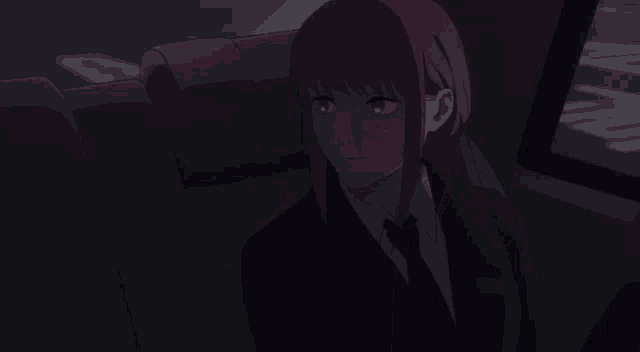 a girl with red hair is sitting in a dark room