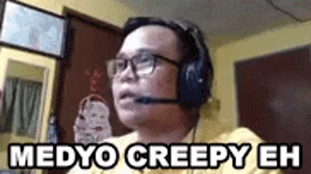 a man wearing headphones and glasses is sitting in a room with the words medyo creepy eh .