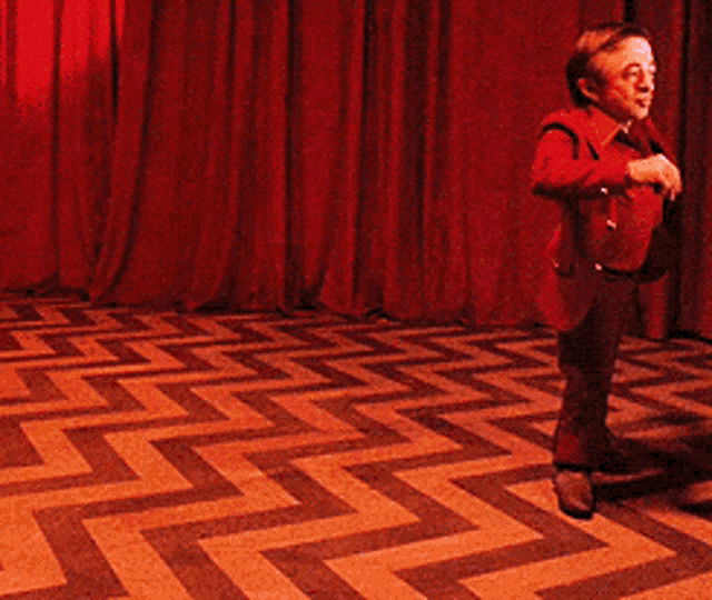 a man in a red suit is standing on a zig zag floor