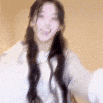 a blurry picture of a woman with long hair making a face .