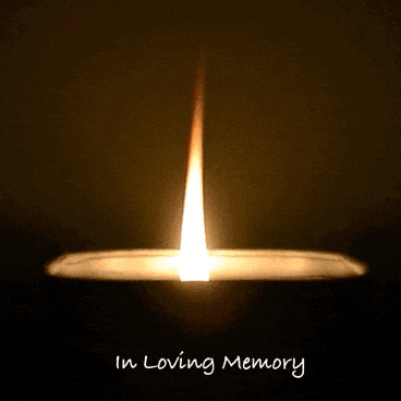 a candle with the words in loving memory written below it