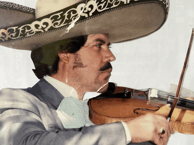a man wearing a sombrero and playing a violin