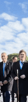 a group of men in suits and ties are walking down the street