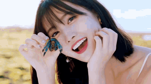 a woman is holding a blue crab in her hands .