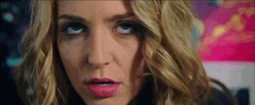 a close up of a woman 's face with a pink lip and blue eyes .
