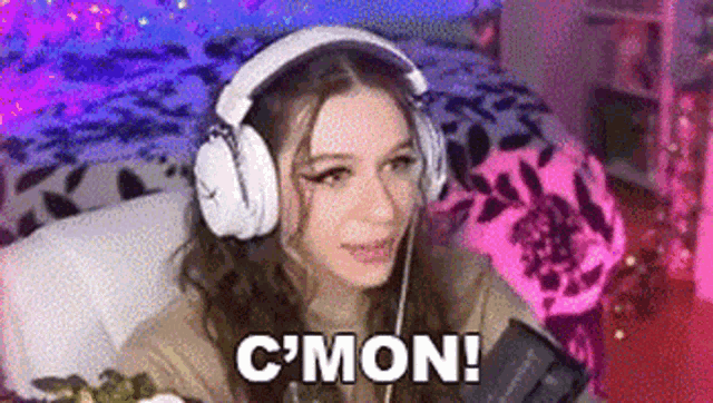 a woman wearing headphones is sitting on a couch in a bedroom .