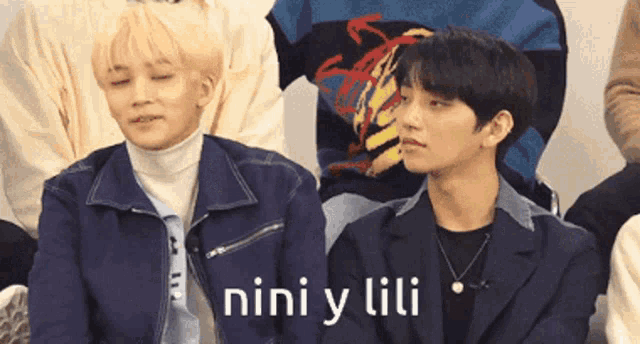 two young men are sitting next to each other and the words nini y lili are visible